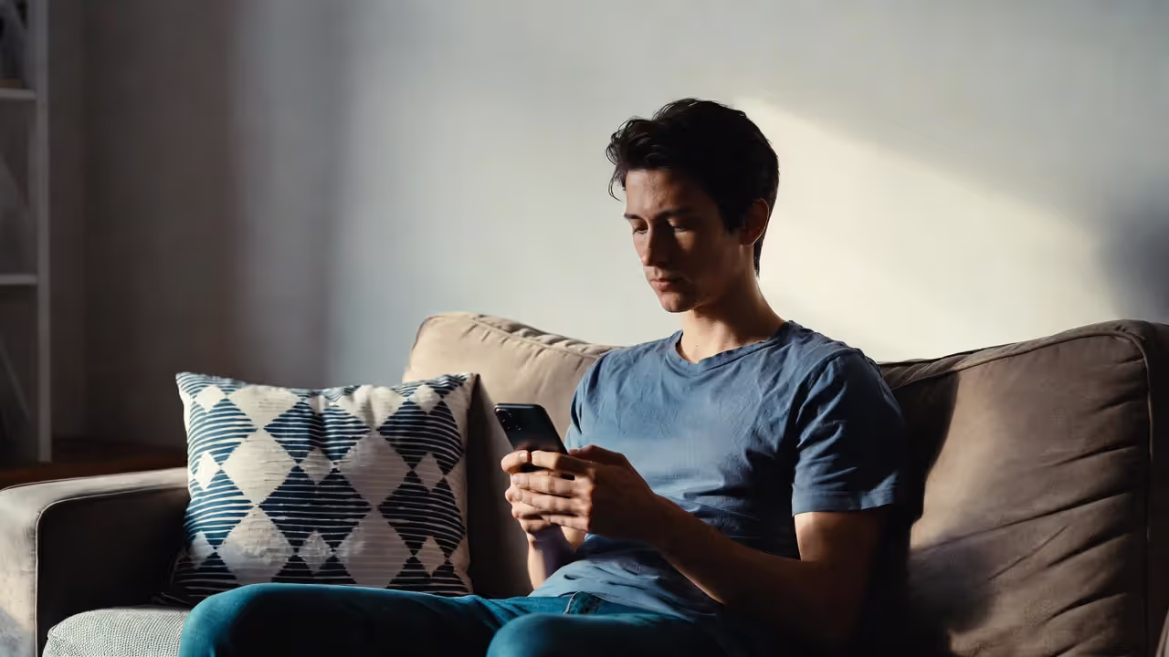 A person is sitting on the sofa, talking on the phone in a relaxed atmosphere